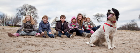 Dog panting and standing in front of a group of kids